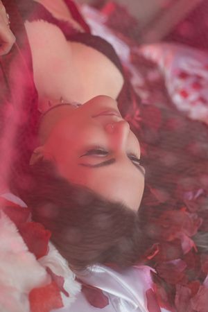 Artistic portrait with soft red lighting and dreamy atmosphere in boudoir photography style.