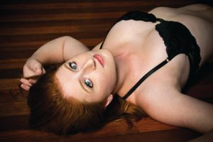 Intimate portrait on wooden floor with black lingerie.