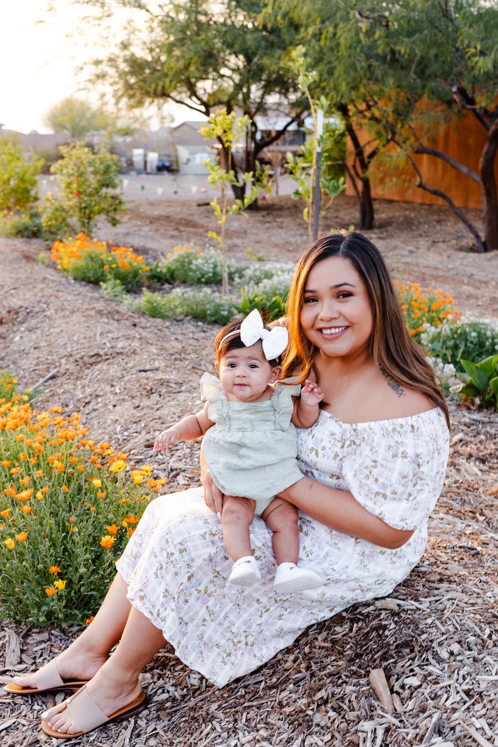 A joyful outdoor portrait surrounded by blooming orange wildflowers in a desert landscape.