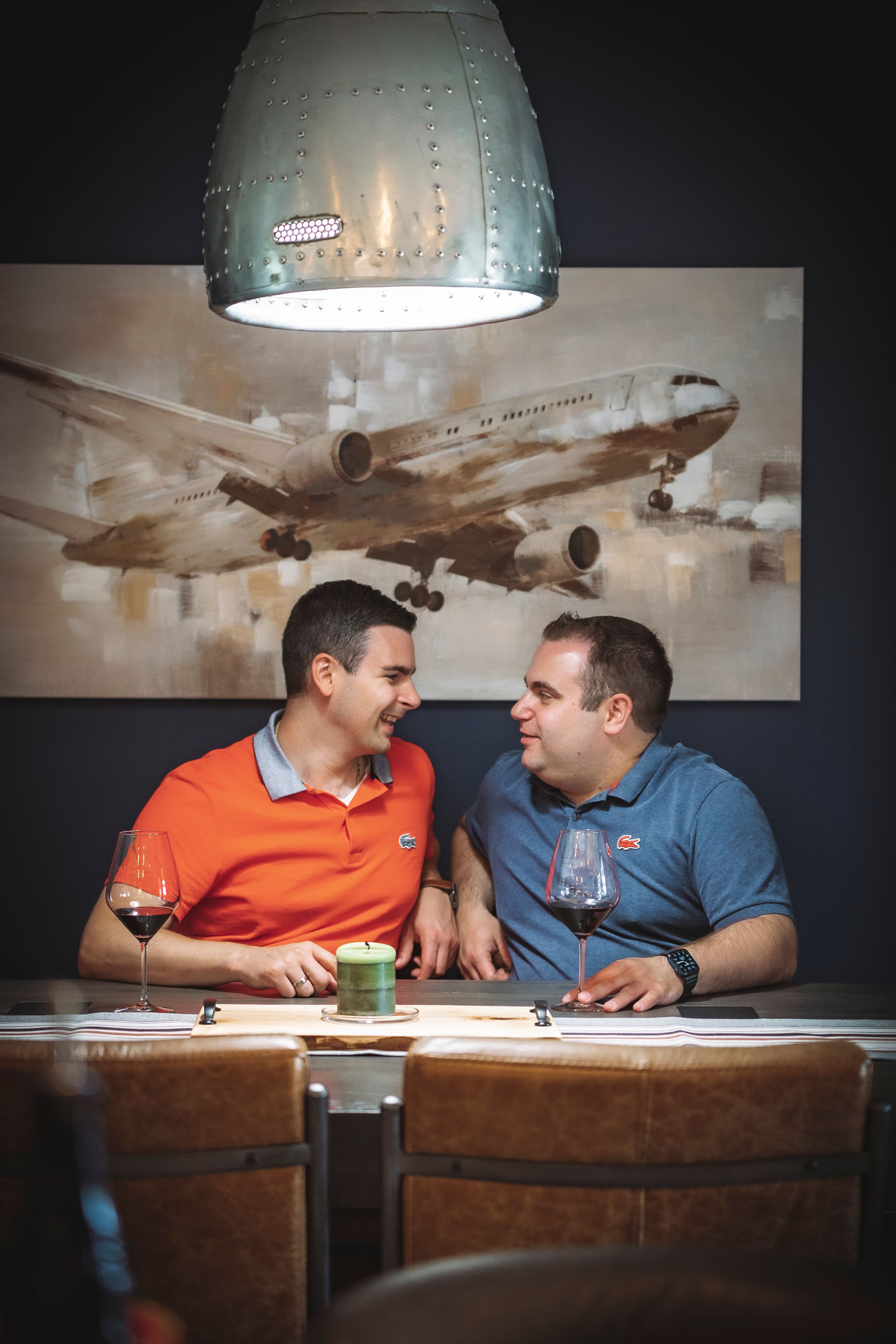 Two people dining together under airplane artwork in a dimly lit restaurant setting.