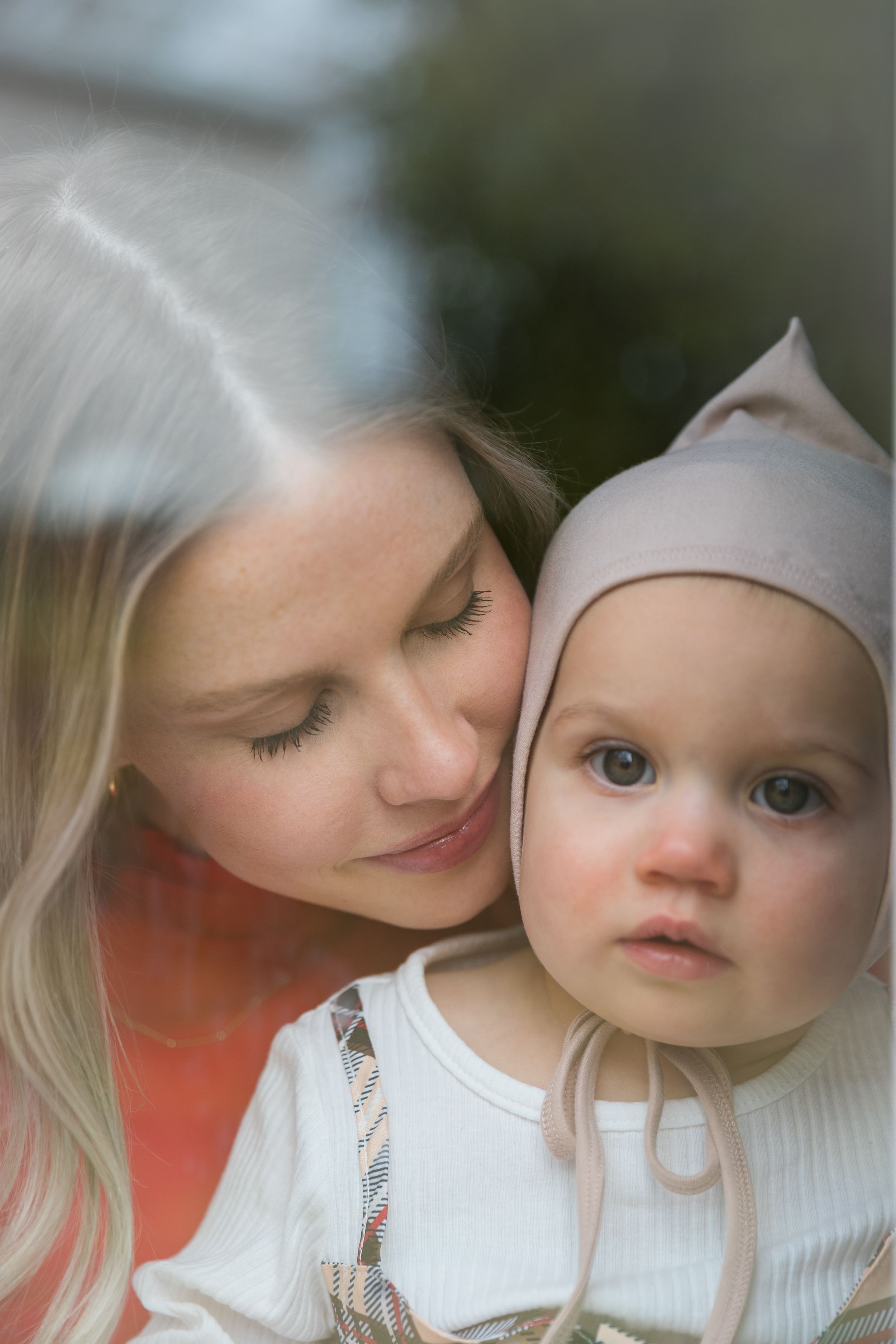 Intimate close-up portrait through glass with soft natural lighting.