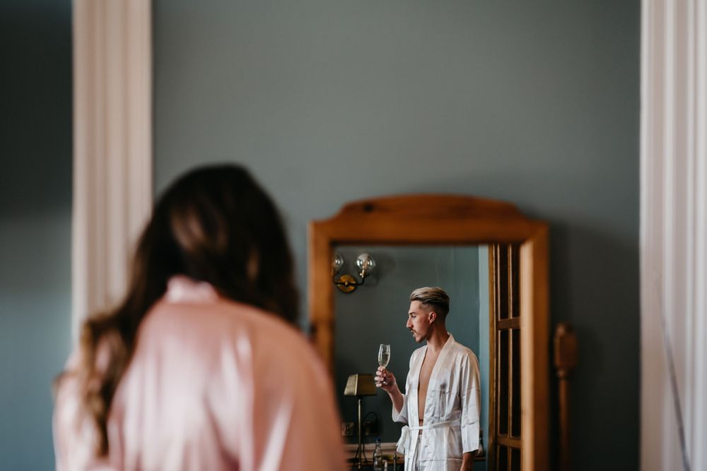 Artistic mirror reflection capturing pre-wedding moments in soft lighting.