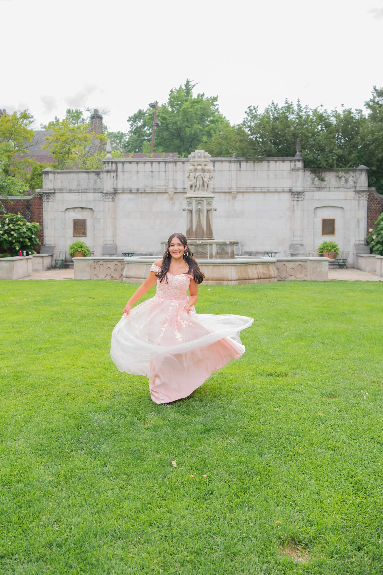 girl in pink gown dancing near fountain in mellon park