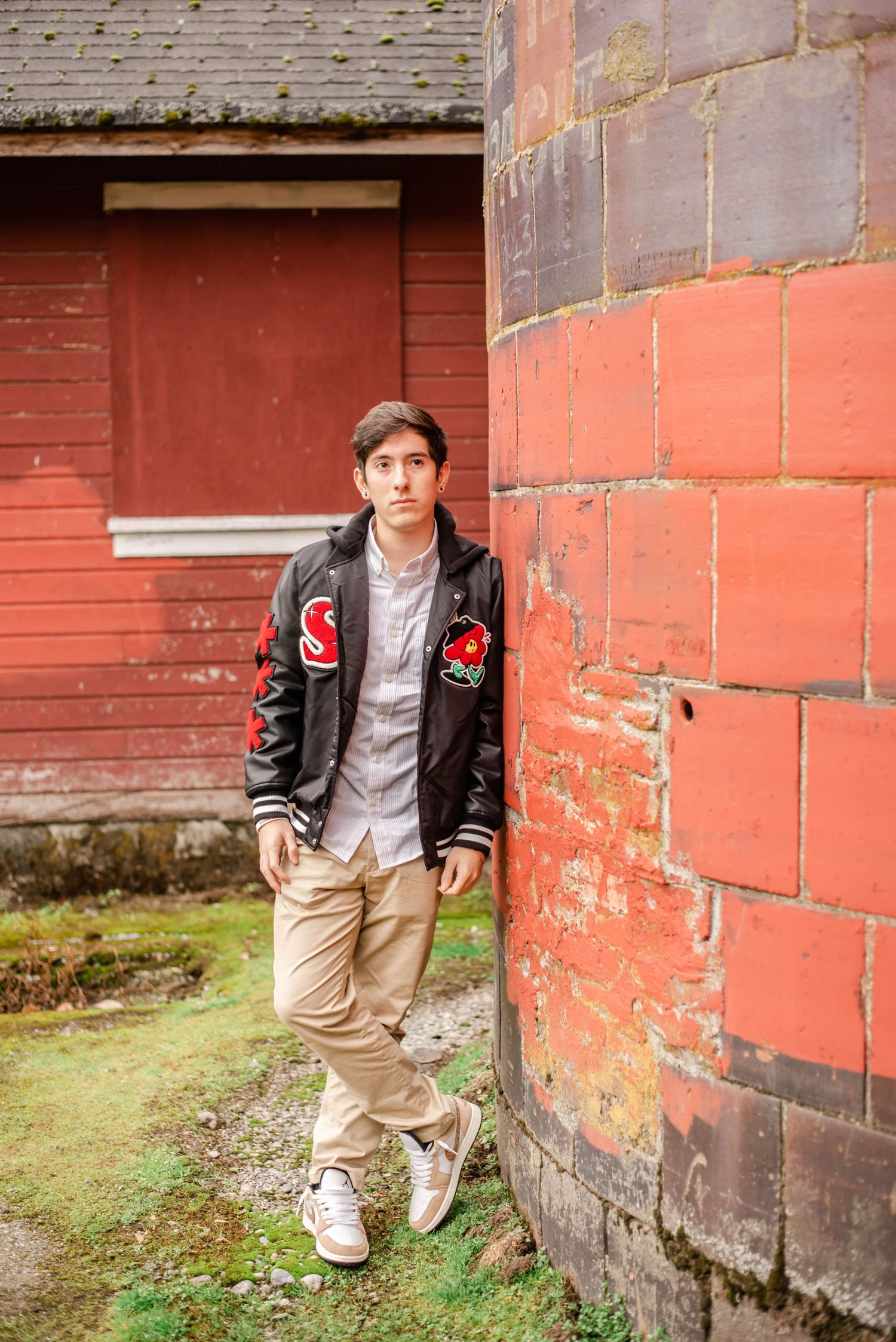 Series of poses against weathered red barn wall in casual attire.