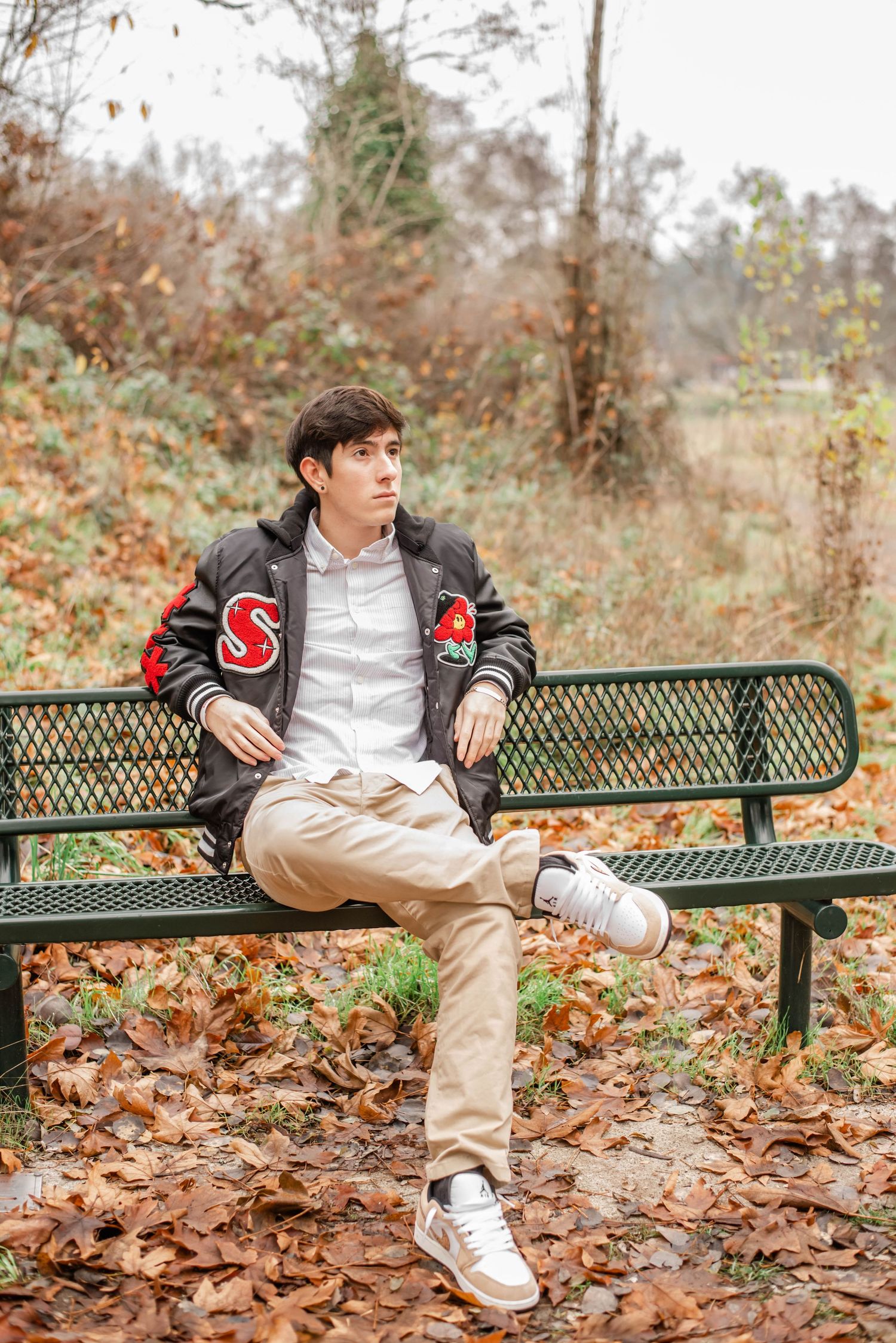 Casual outdoor portraits on park bench with fallen autumn leaves.