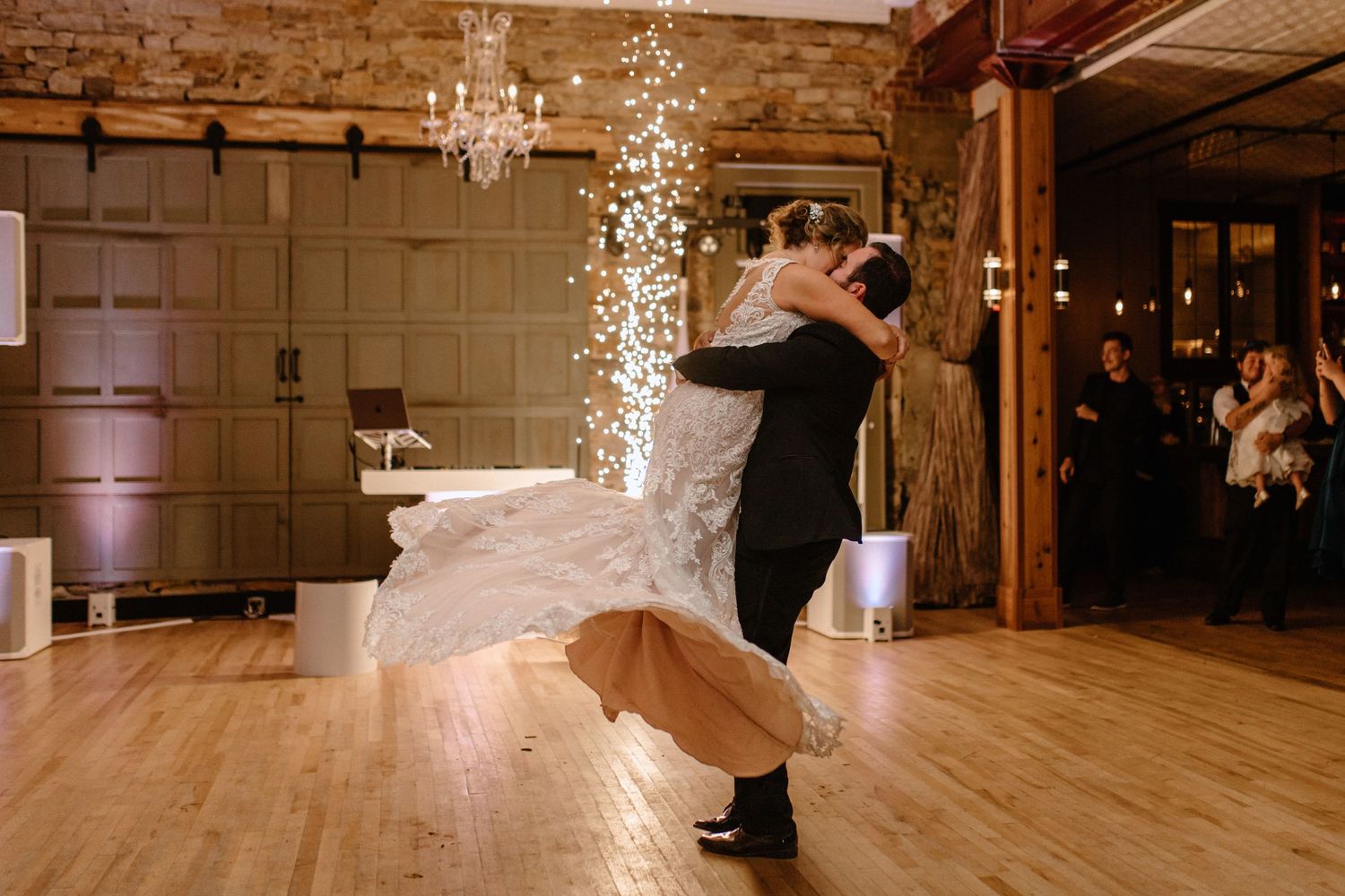Couple dancing with sparklers at rustic wedding reception venue.