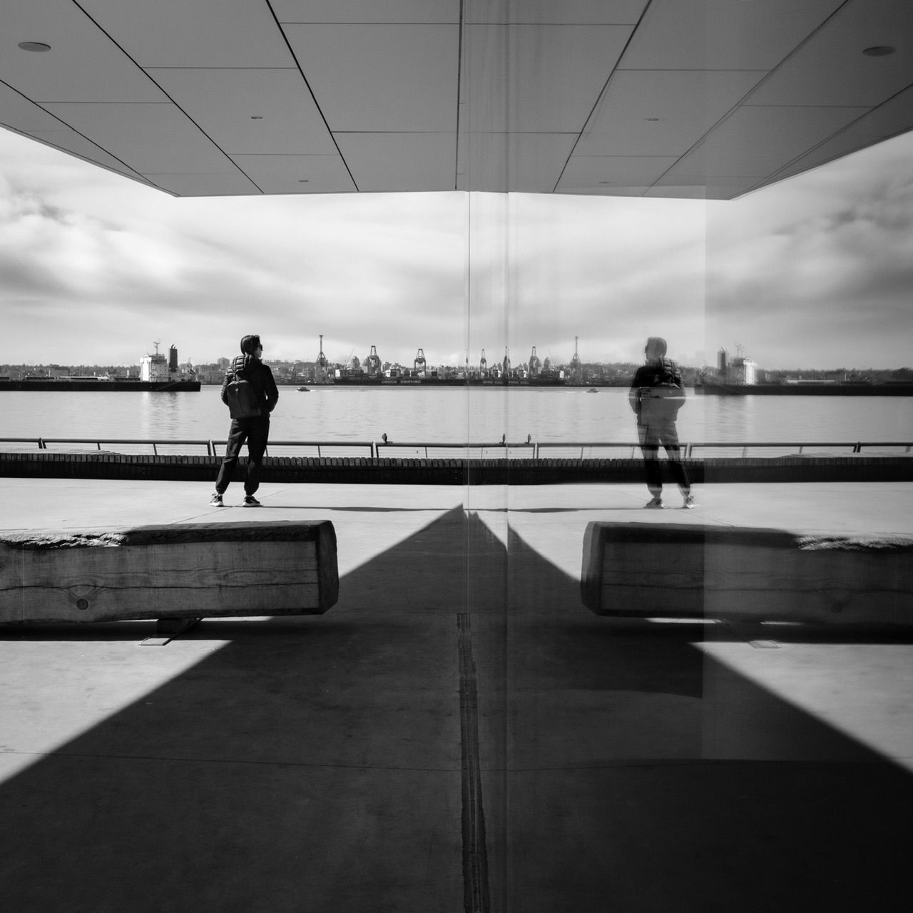 Black and white photo of person standing on elevated walkway, architectural location, Polygon Gallery North Vancouver