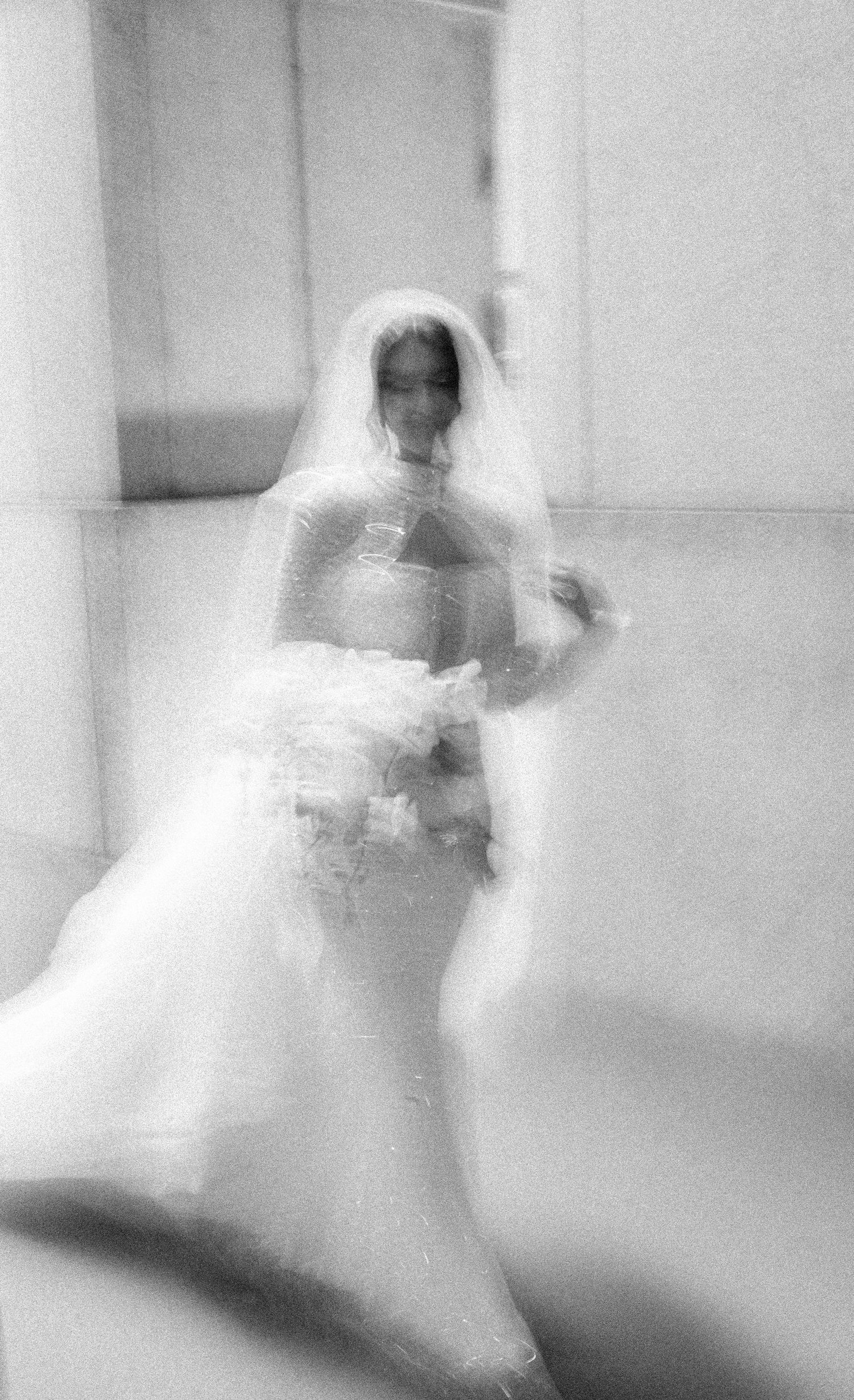Ethereal black and white photo of a bride in motion creating a dreamy, blurred effect.