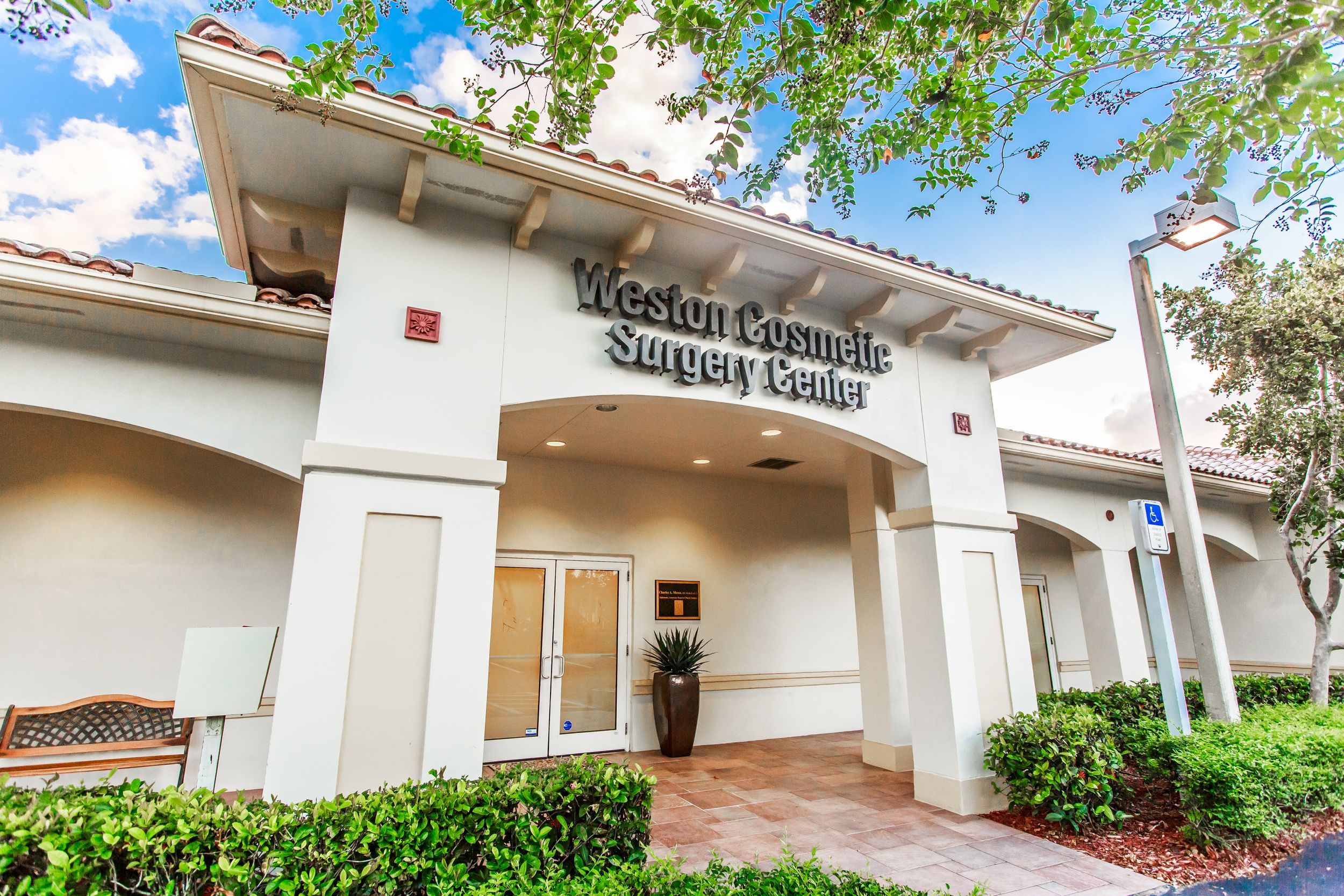 Exterior view of modern medical facility with Spanish tile roof and landscaping.