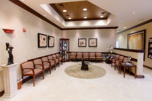 Medical waiting room with wood ceiling detail and comfortable seating arrangement.