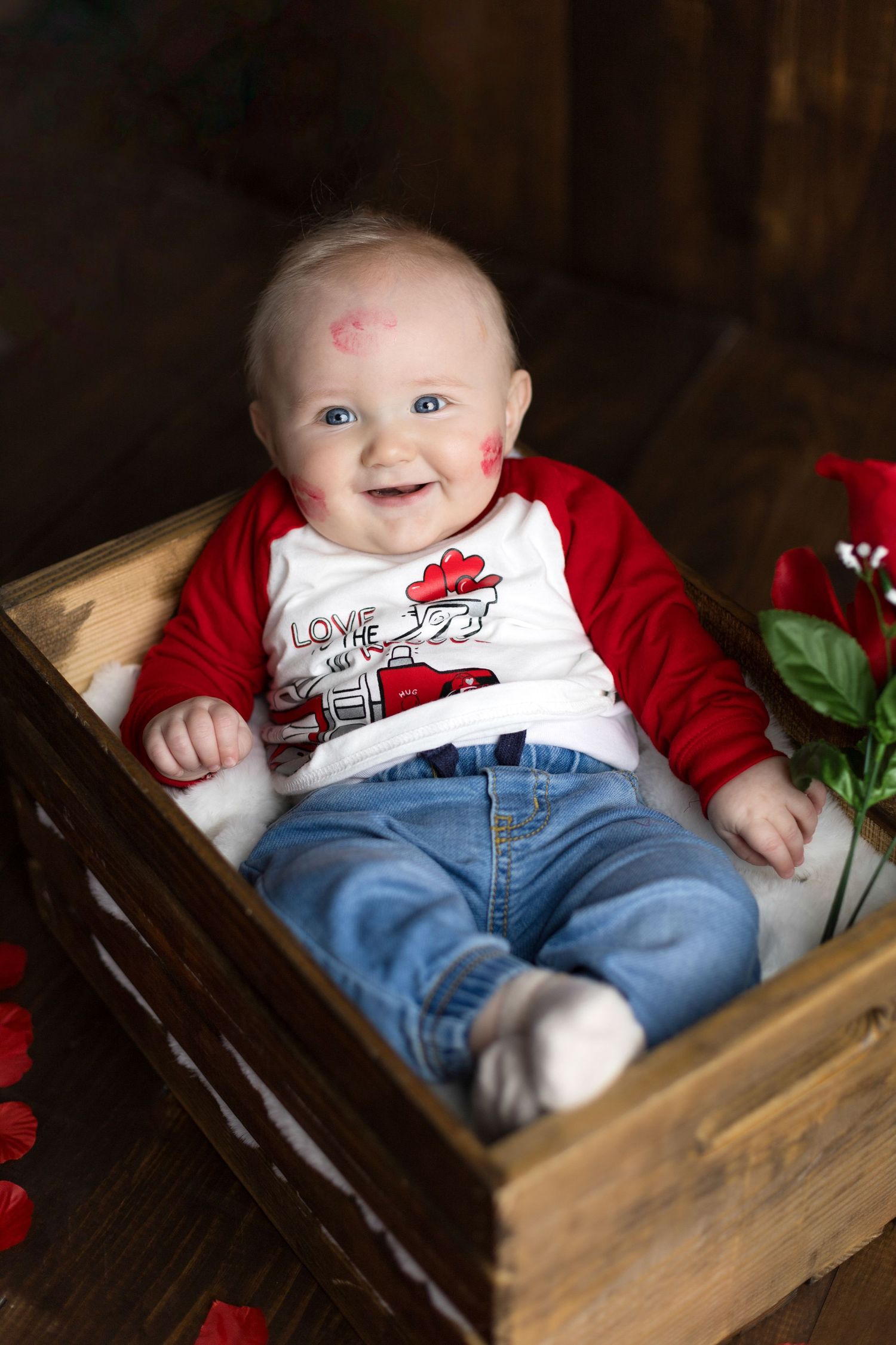 Valentine's themed baby photo with heart decorations and red accents.