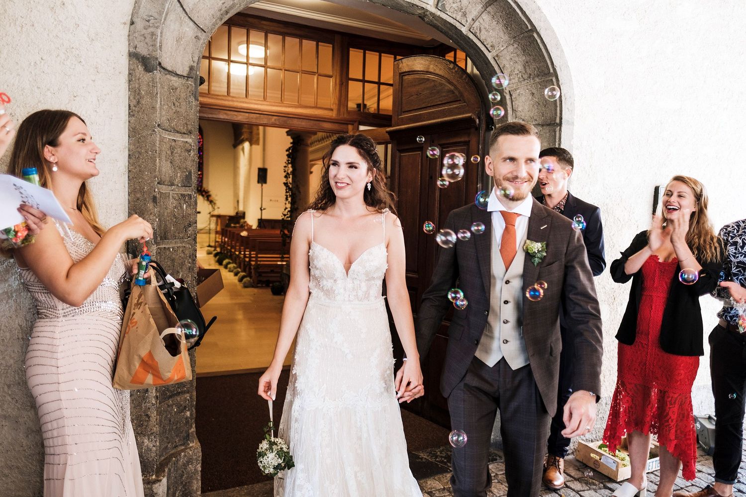 TLOOK photographe de mariage de style documentaire, les mariés sortent de l'église avec bulles