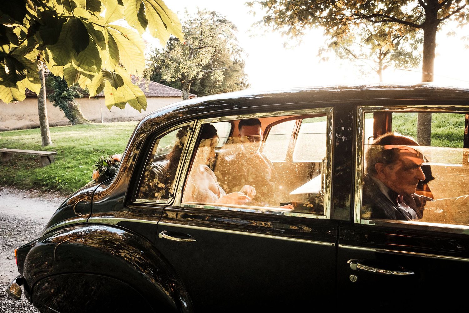 TLOOK photographe de mariage de style documentaire, les mariés dans la voiture ancienne avec chauffeur