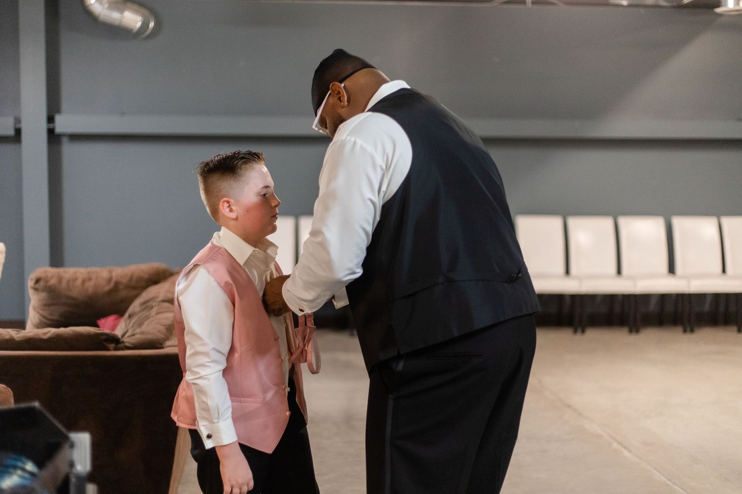 Wedding ceremony preparations in a modern indoor venue with formal attire.