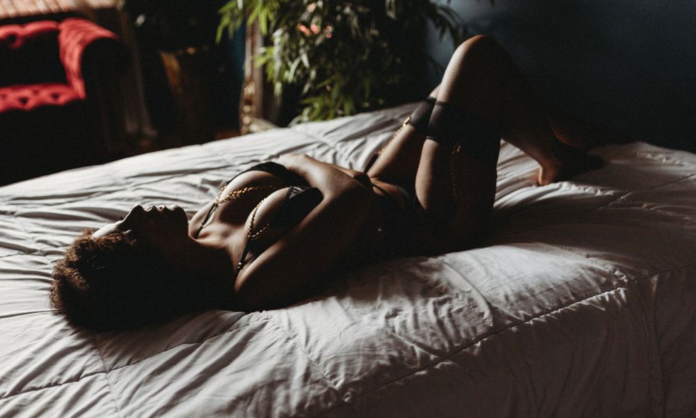 Artistic black and white boudoir photography on white bedding.