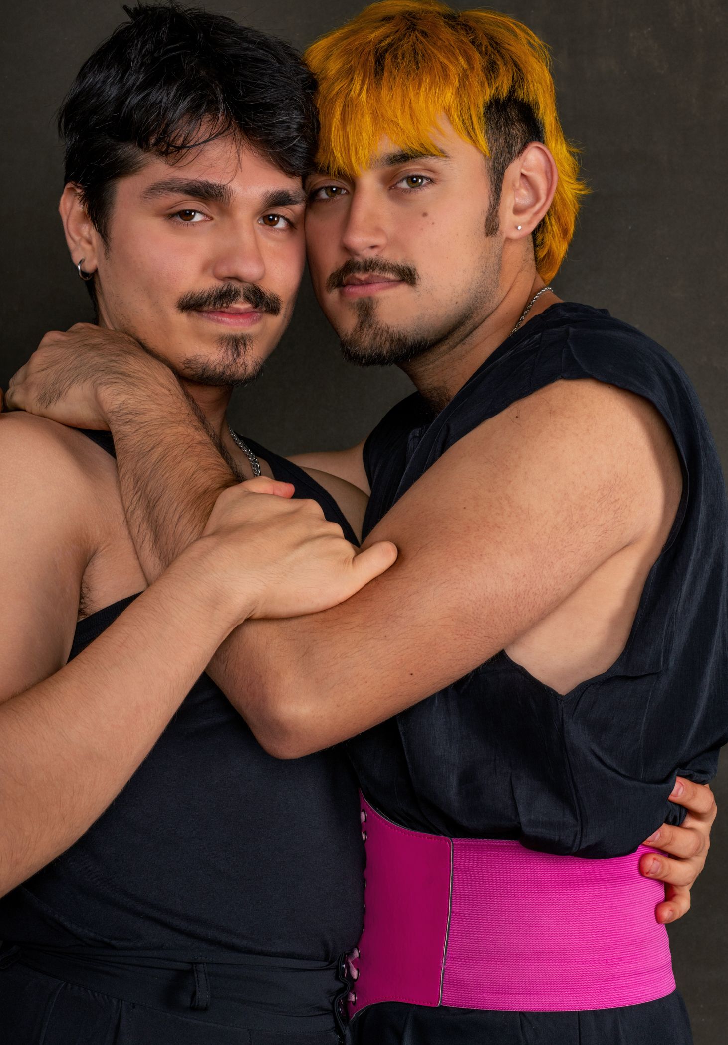 Two people embrace in a series of intimate poses against a dark background.
