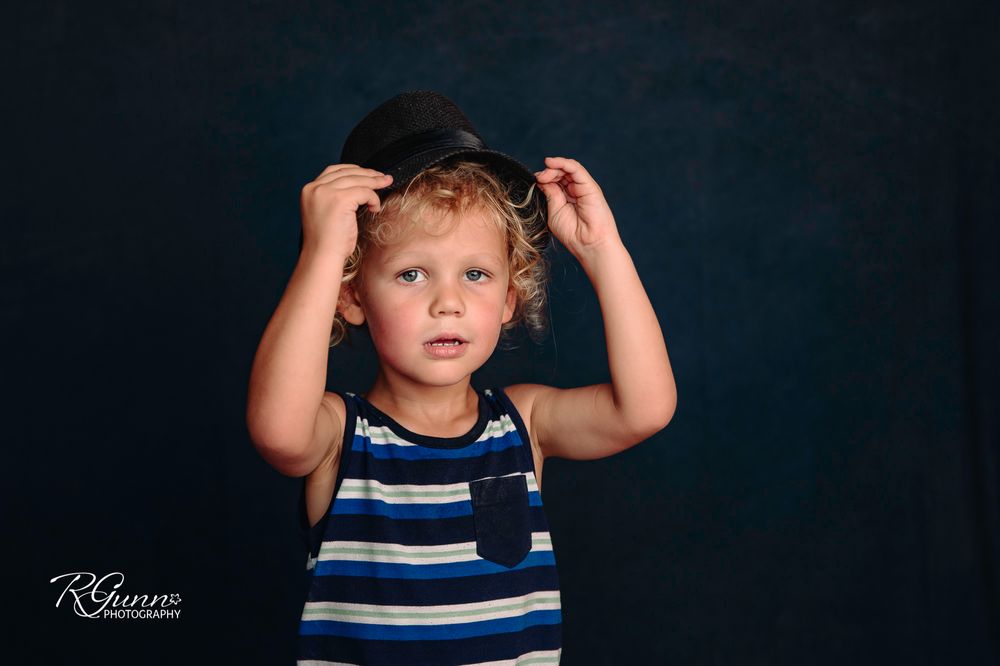 in home studio in Tulsa oklahoma with hat and dark backdrop