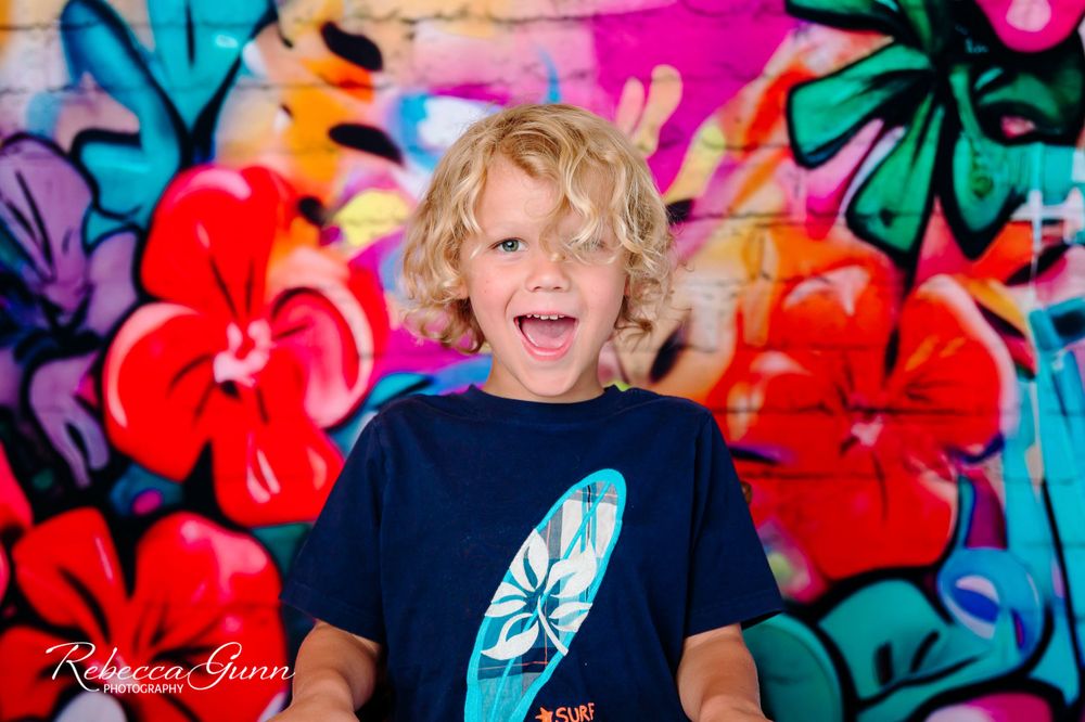 tropical and surfer theme in home studio session located in tulsa oklahoma; young boy is excite and wearing a surf shirt