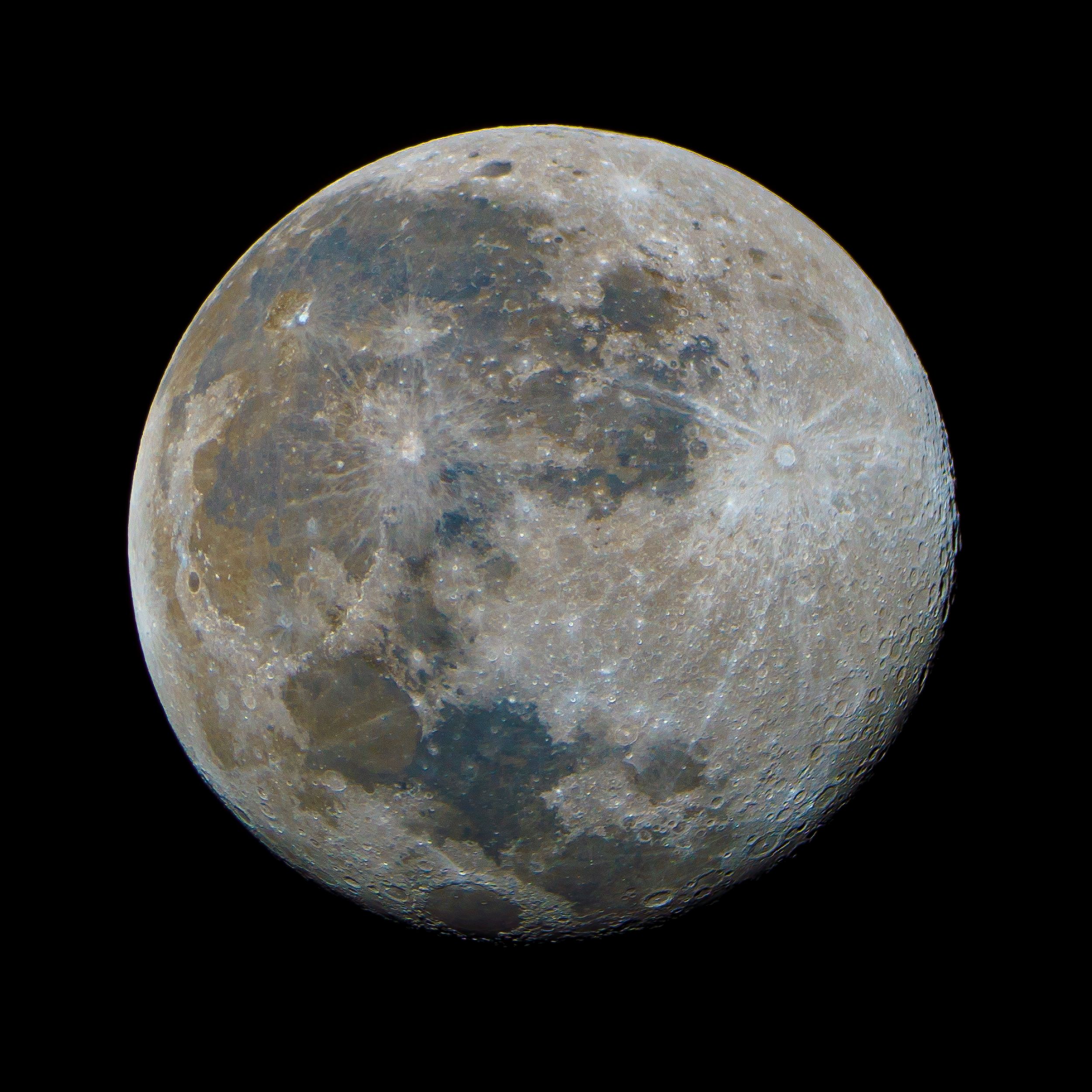 A full Moon shown in natural color revealing its dark maria regions and bright highland areas.