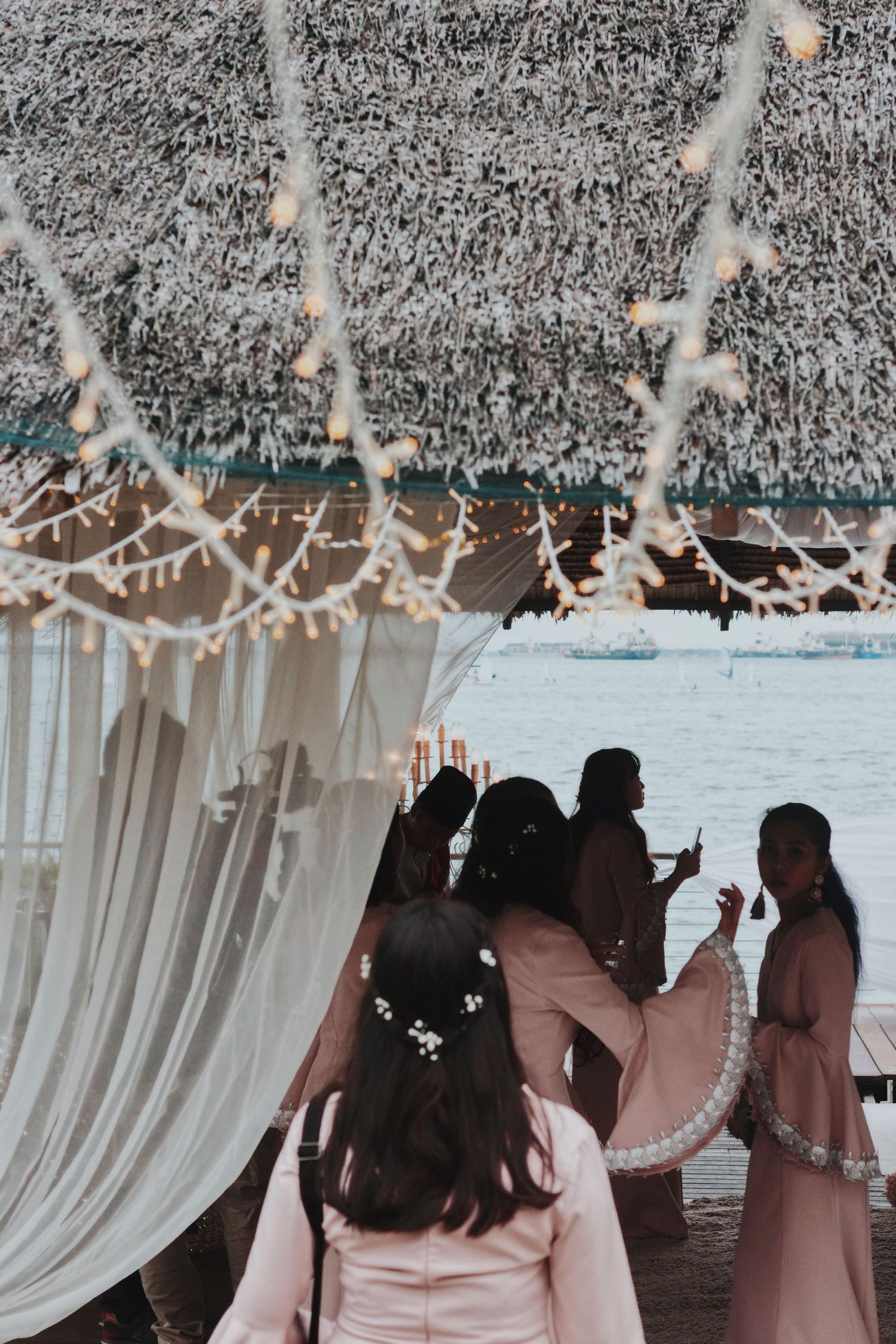 Wedding reception setup with white drapes and string lights creating a romantic atmosphere.