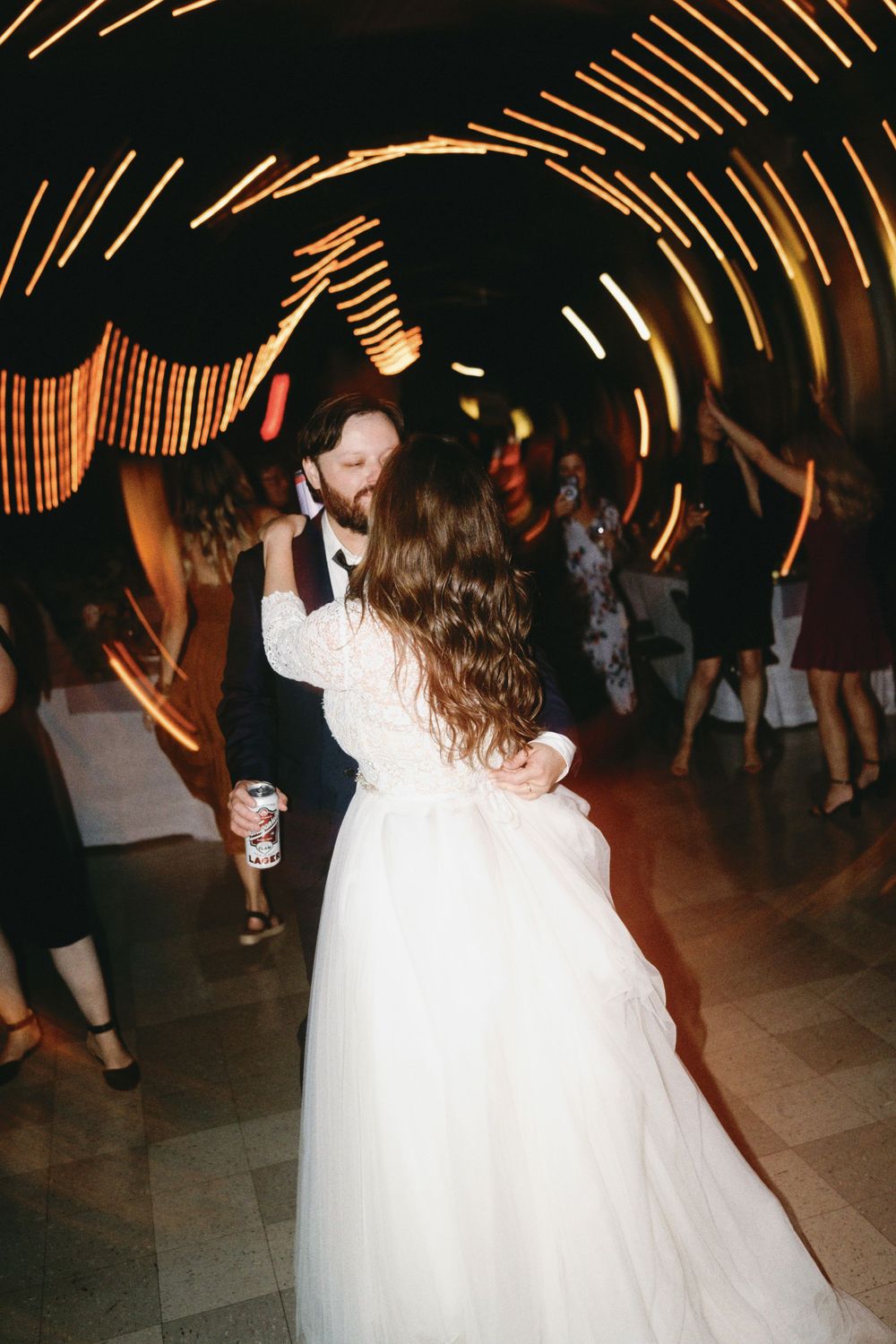 Wedding celebration on dance floor with dramatic lighting and motion blur.