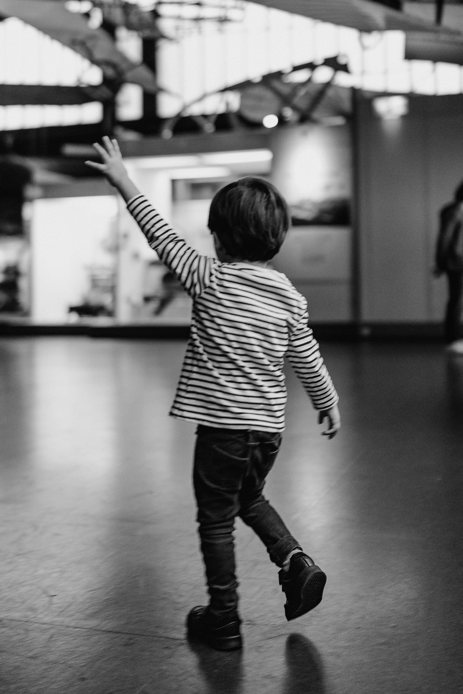 London wedding photographer, son doing plane arms running through the museum