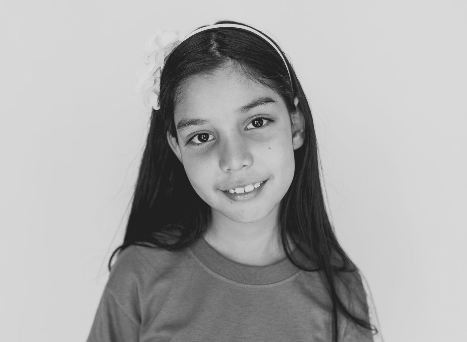 Portrait of a young person with long dark hair wearing a headband.