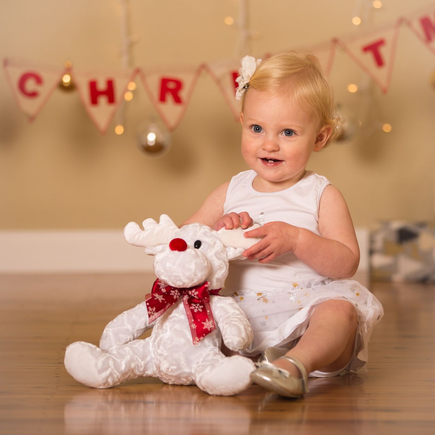 Christmas photo of smiling baby girl in white dress