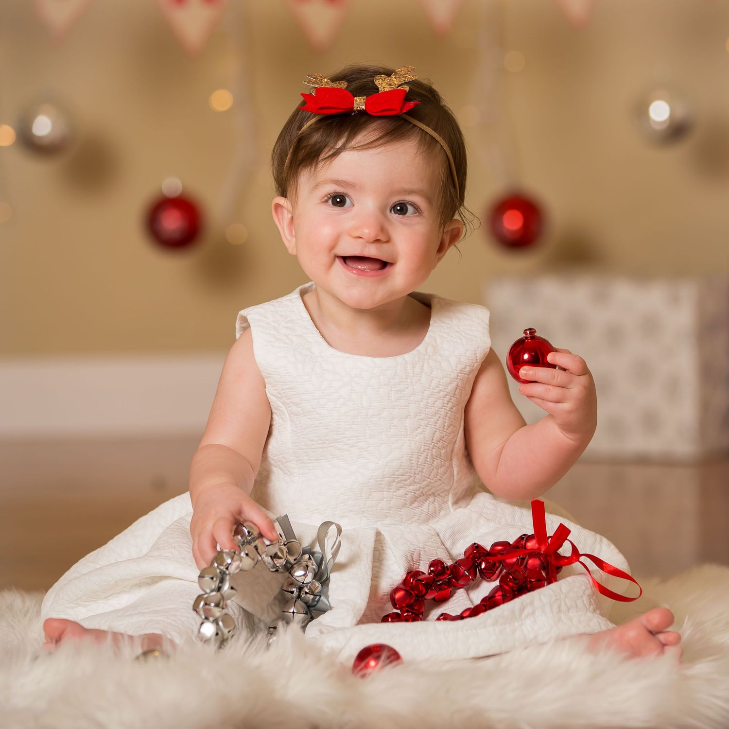 Baby girl smiling for Christmas photo in white dress