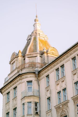 Ornate historic building with a golden dome and decorative facade glowing in warm evening sunlight.