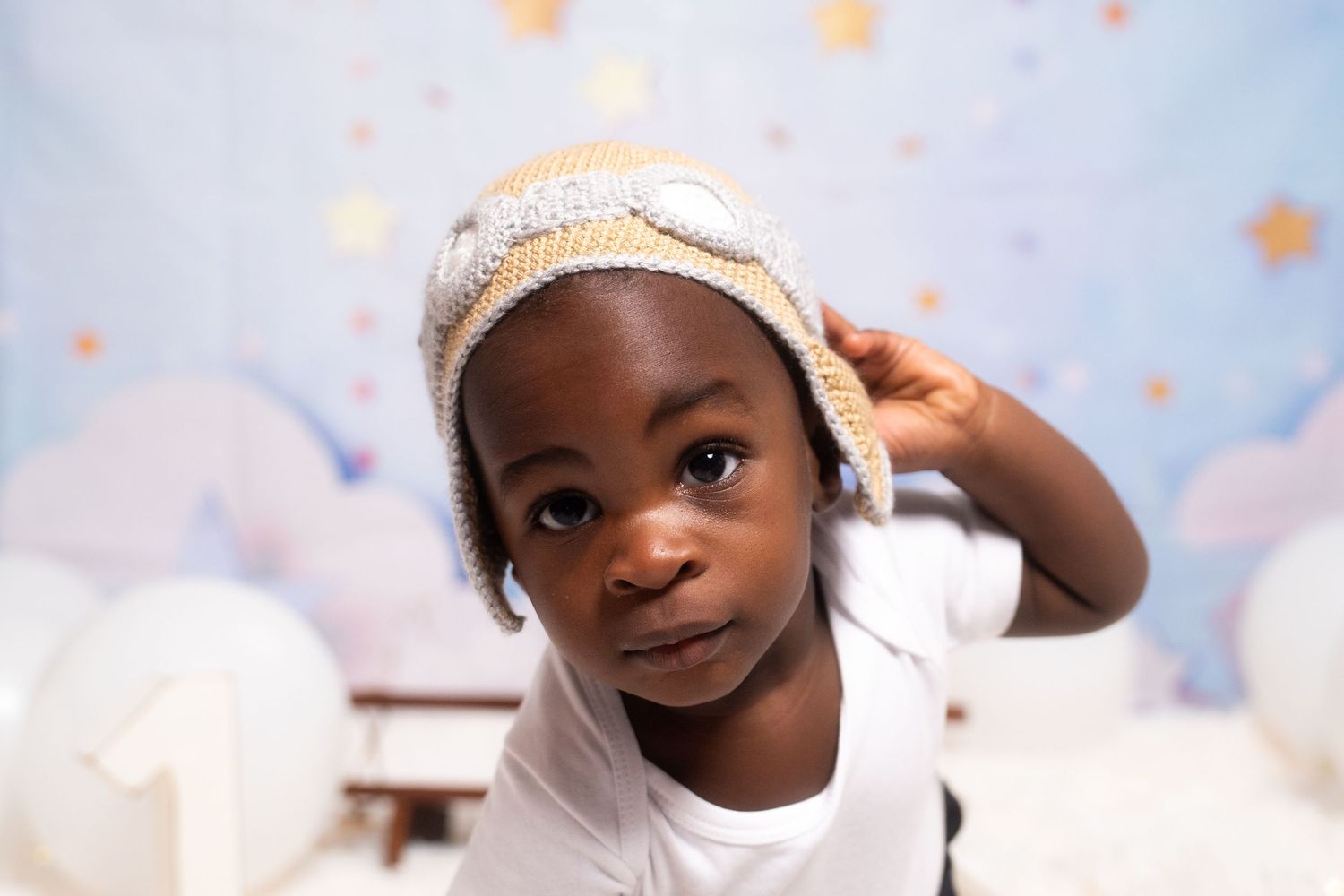 Baby photoshoot with dreamy cloud backdrop and soft pastel stars.