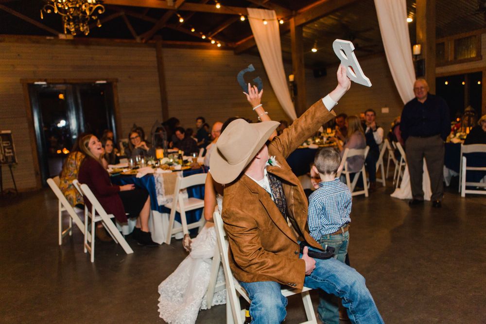 A wedding guest plays with a cloth napkin during reception entertainment.