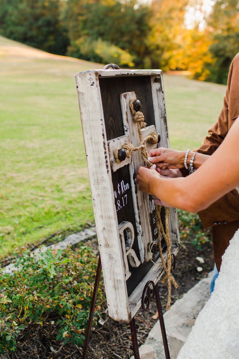 Close-up of rustic unity cross ceremony ritual at outdoor wedding.