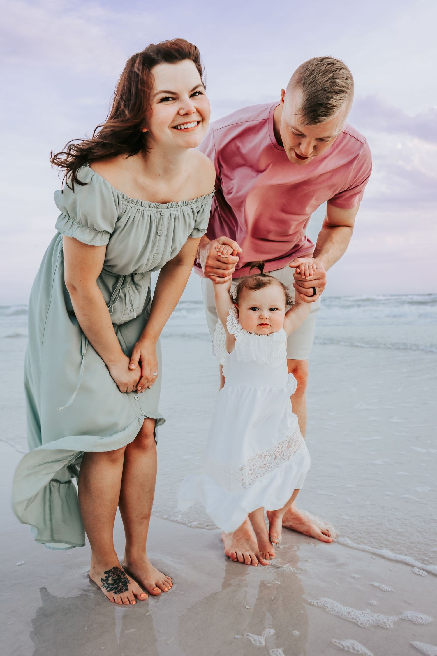 Outdoor Family Session at Indian Rocks Beach in Indian Rocks, FL; baby holding parents hands on beach
