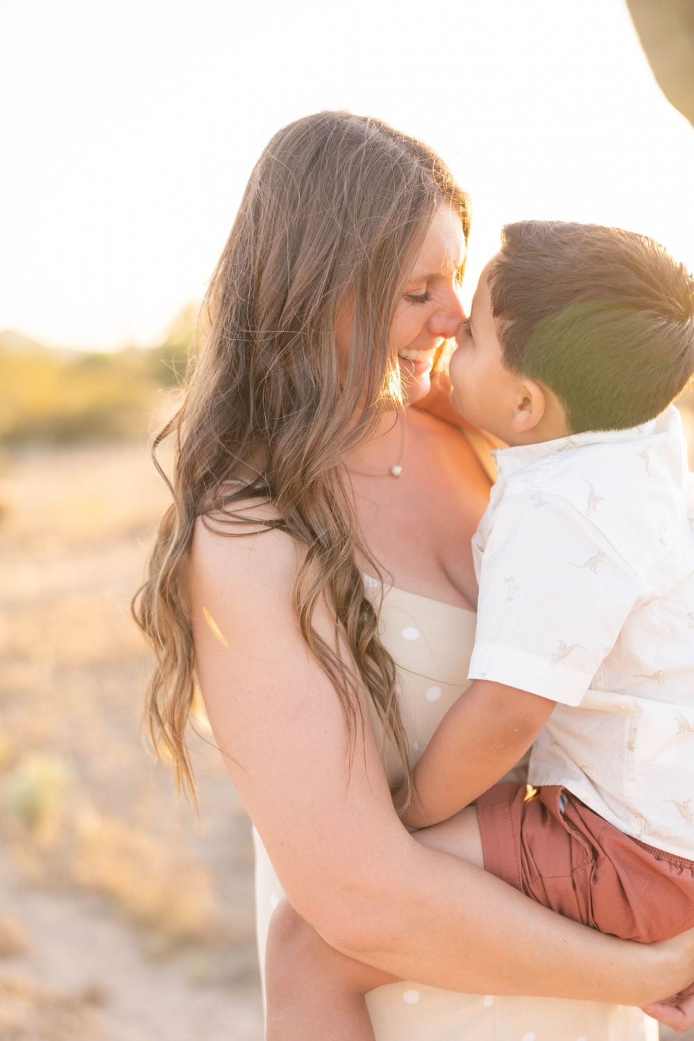Tender moment between parent and child in warm sunset light.