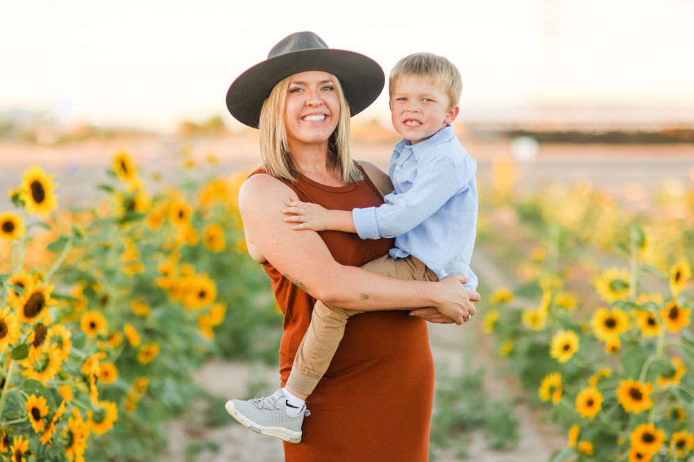 A joyful embrace among bright yellow sunflowers during a sunset photoshoot.