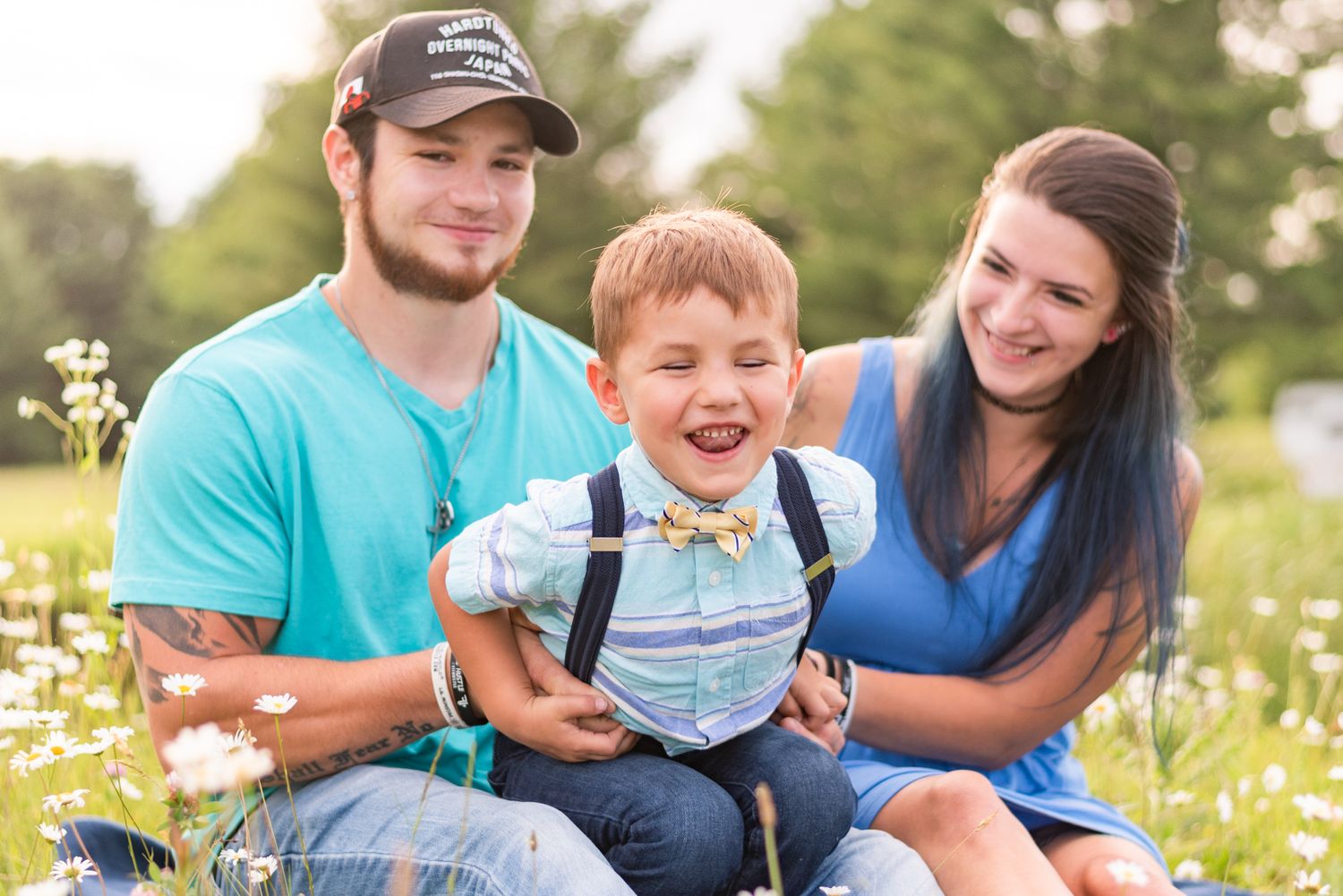 Son being tickled by mom and dad in daisy patch in Clarion Pennsylvania