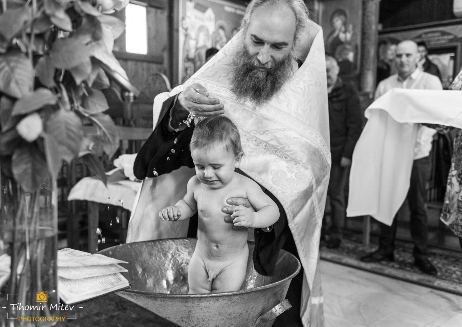 Отец кръщава момченце във варел с вода