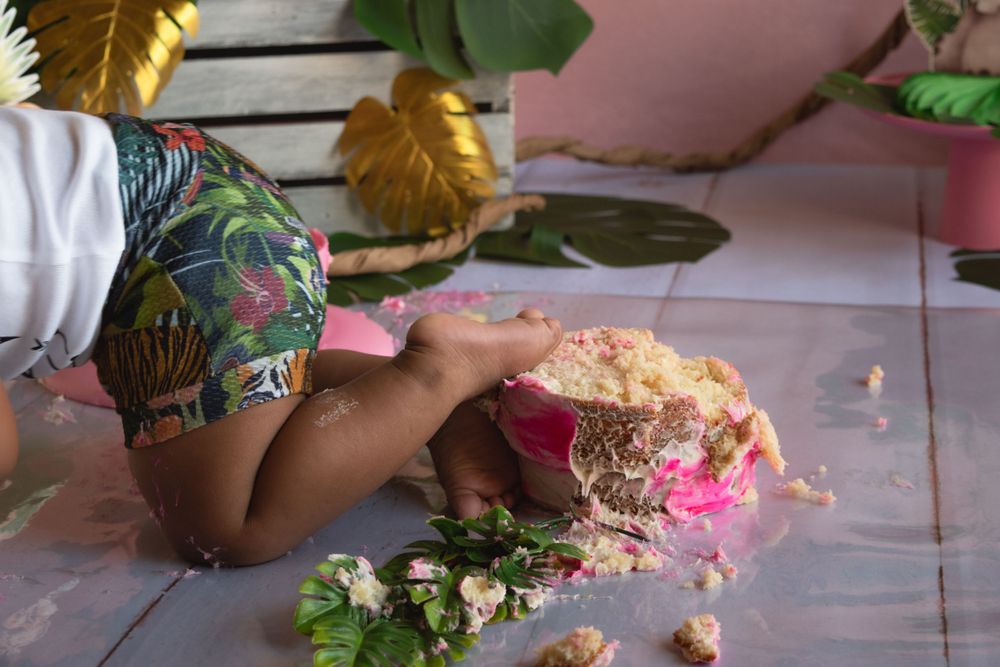 Close-up of hands making or decorating something with pink and floral elements.