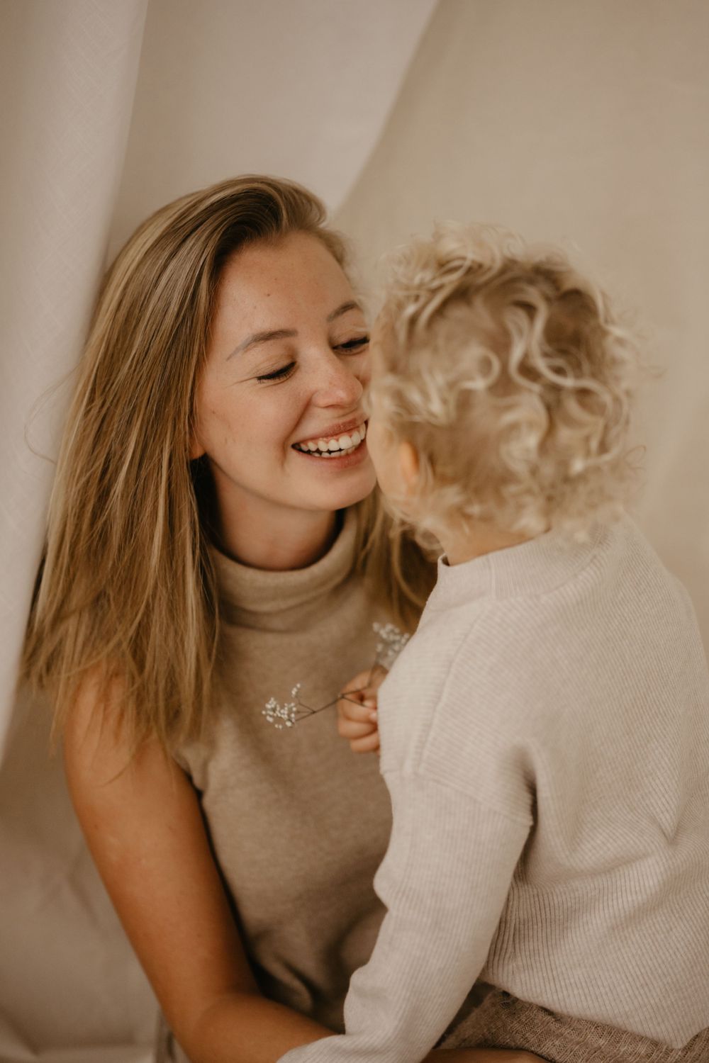 Joyful bonding moment between parent and child in neutral tones.