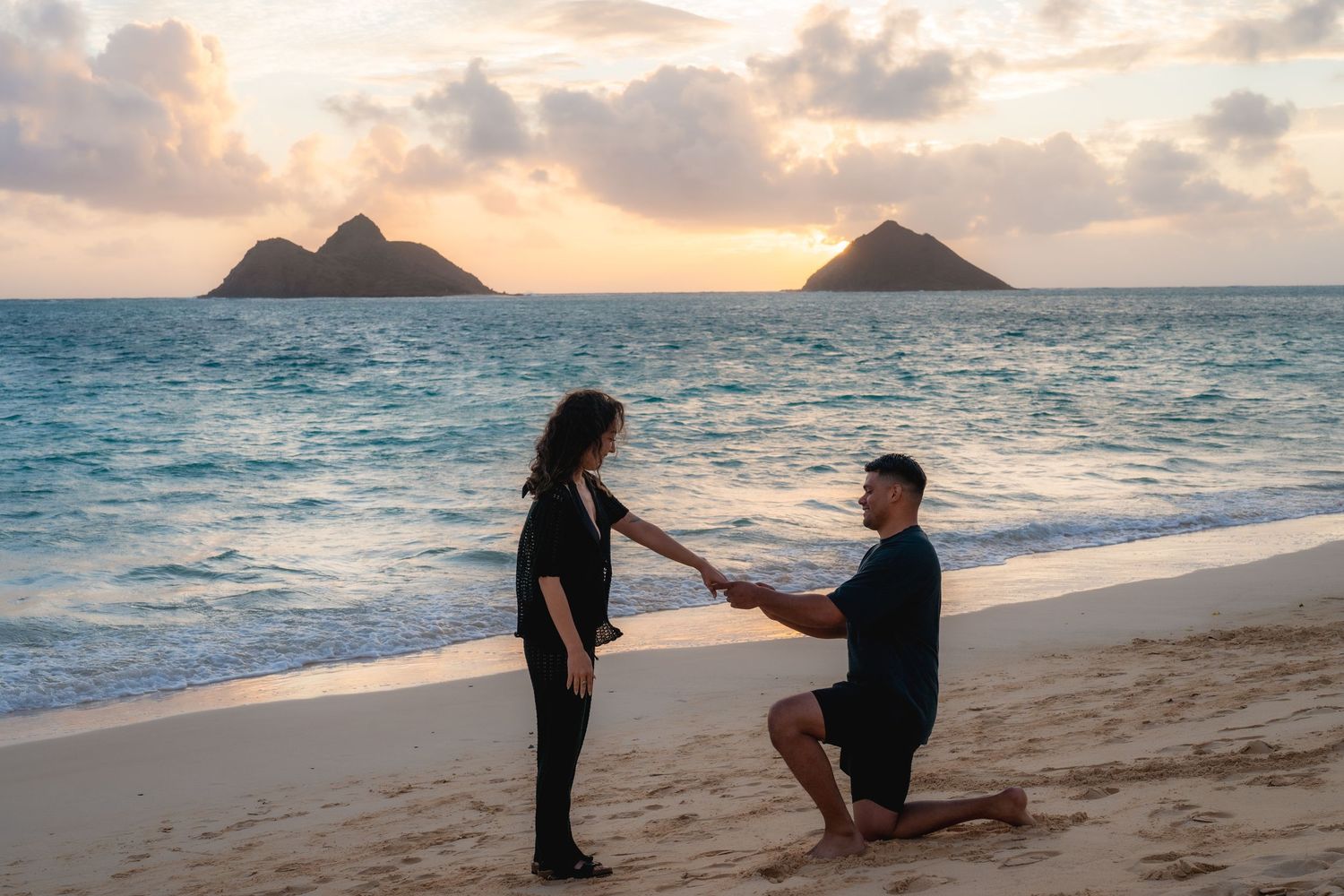 Man and woman kissing on cloudy Waimanalo Beach