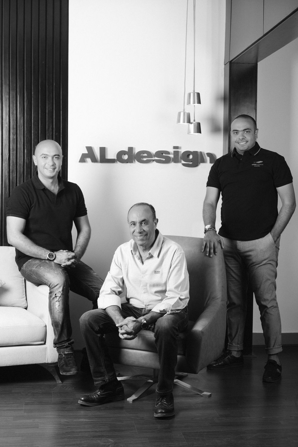 Black and white office photo of three people at ALdesign company.
