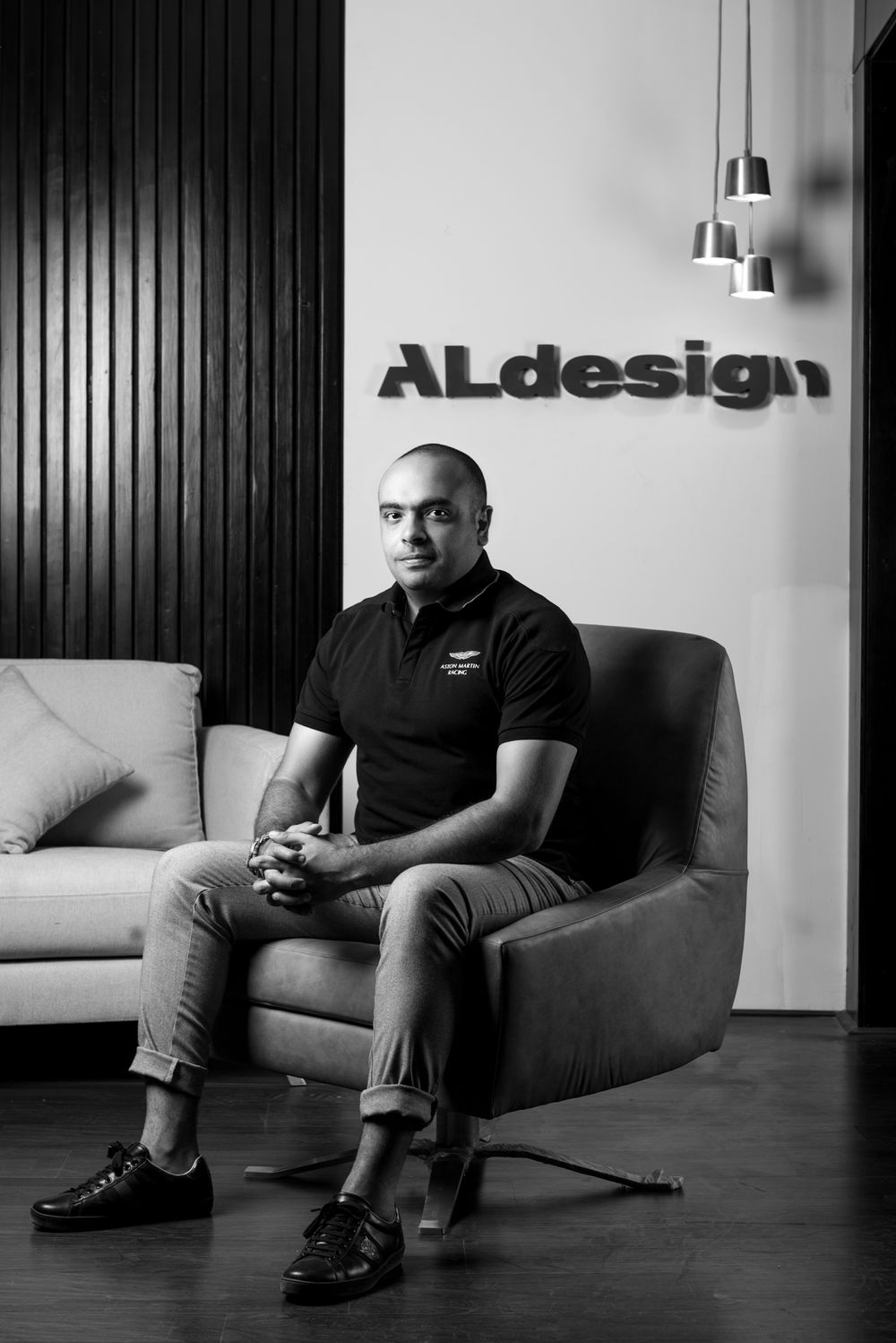 Professional black and white portrait in modern office setting with ALdesign logo and pendant lights.