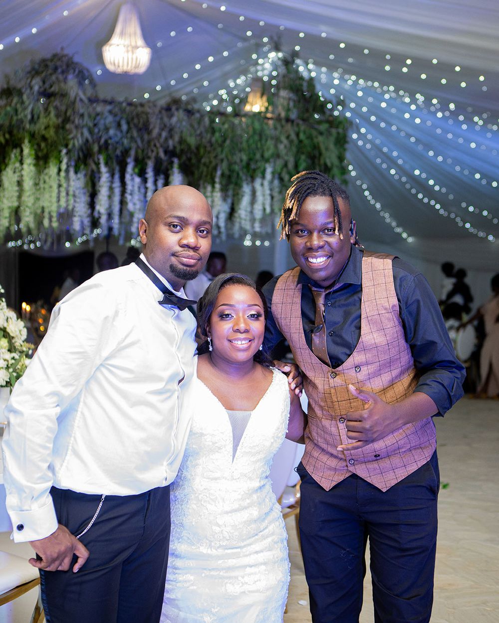 Wedding reception venue decorated with elegant hanging lights and lush greenery.