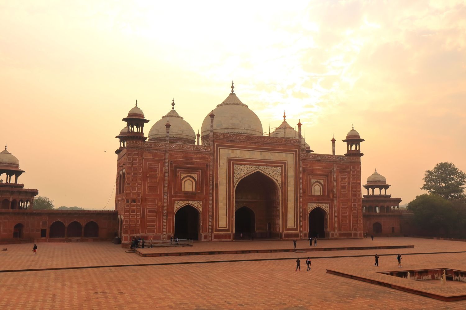 Red sandstone mosque glows during golden hour in Agra, India.