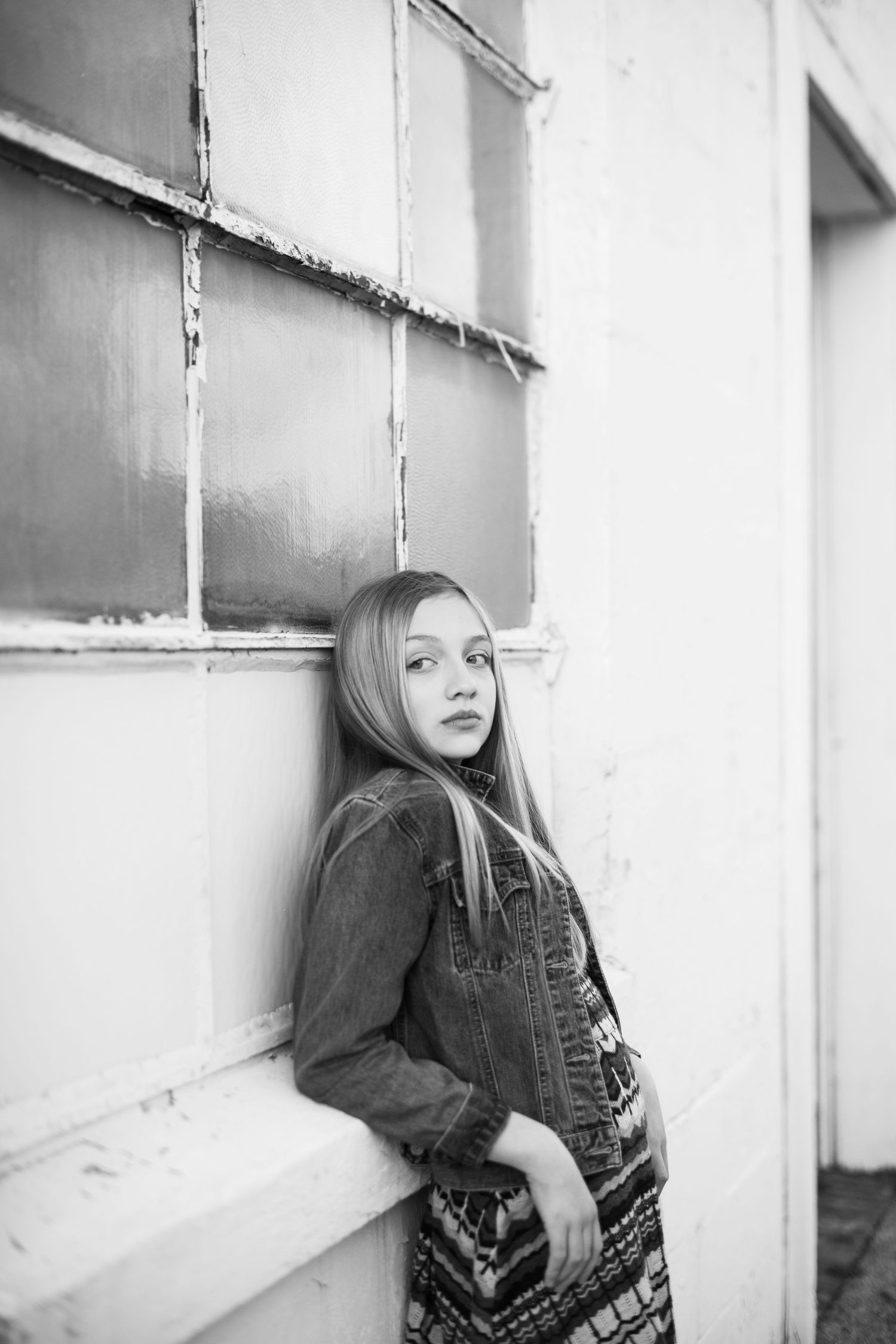 Artistic black and white portraits against white wall featuring denim fashion styling.