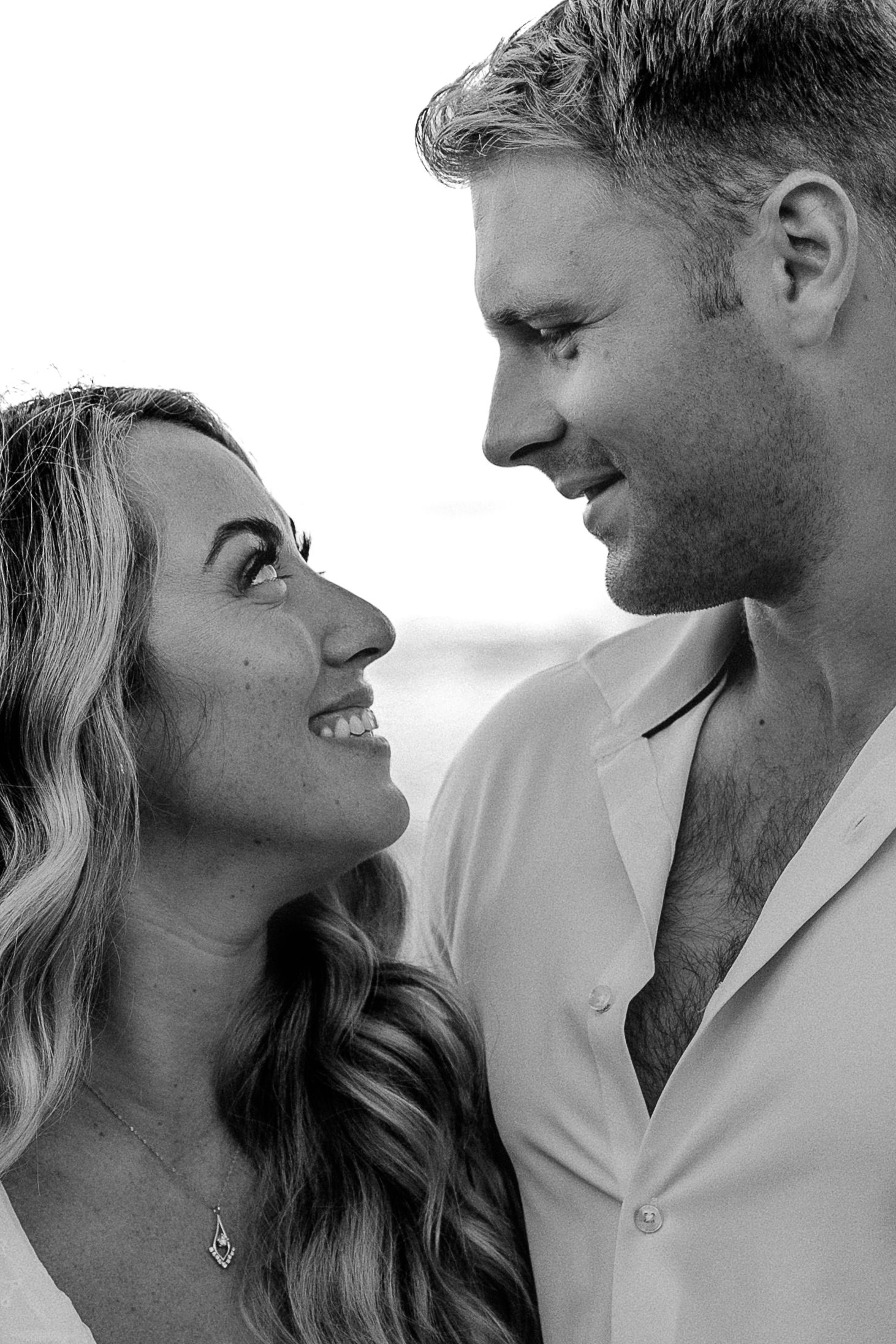 Romantic black and white close-up portrait of a couple sharing an intimate moment.