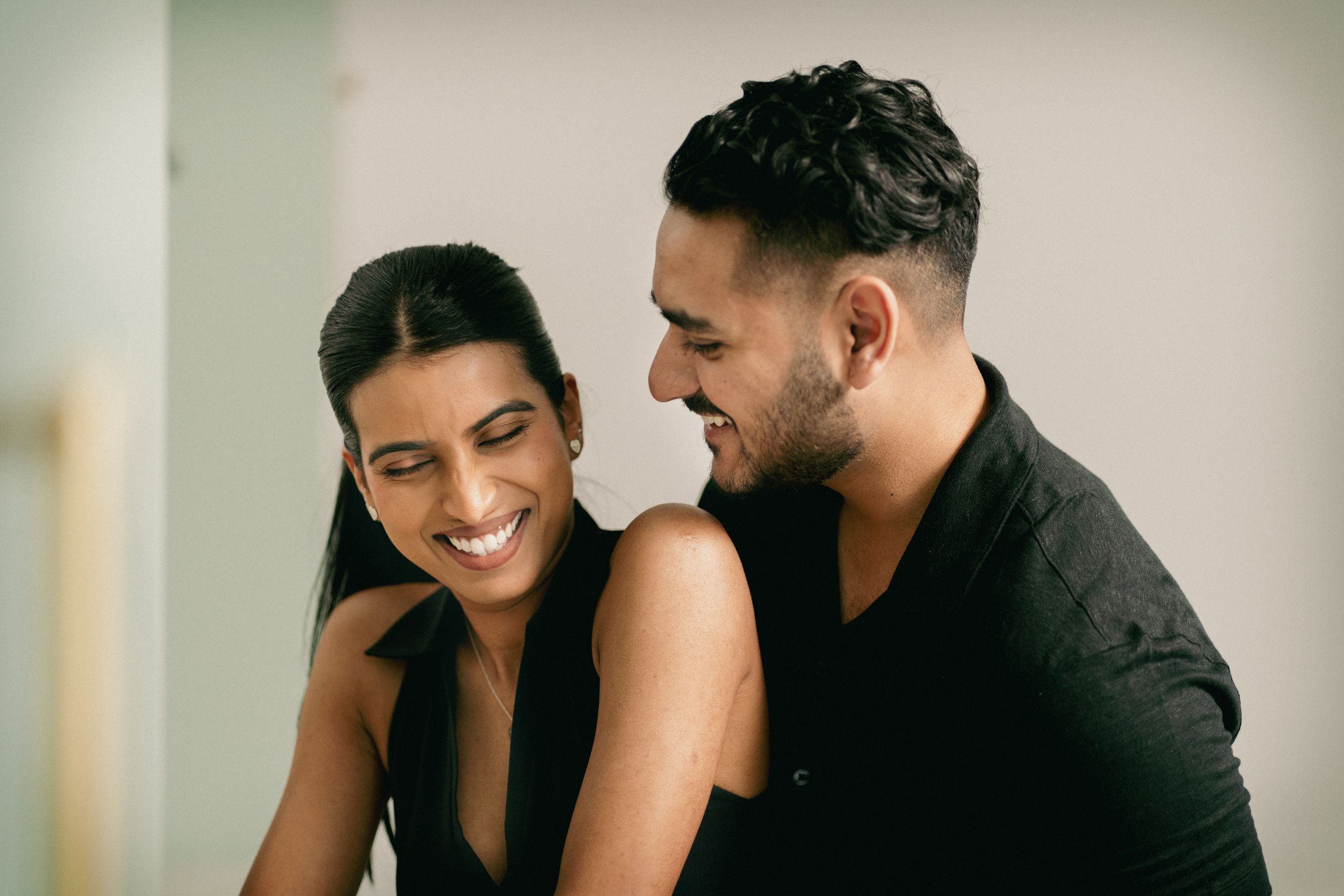 A couple shares a joyful moment while cooking together in their kitchen.