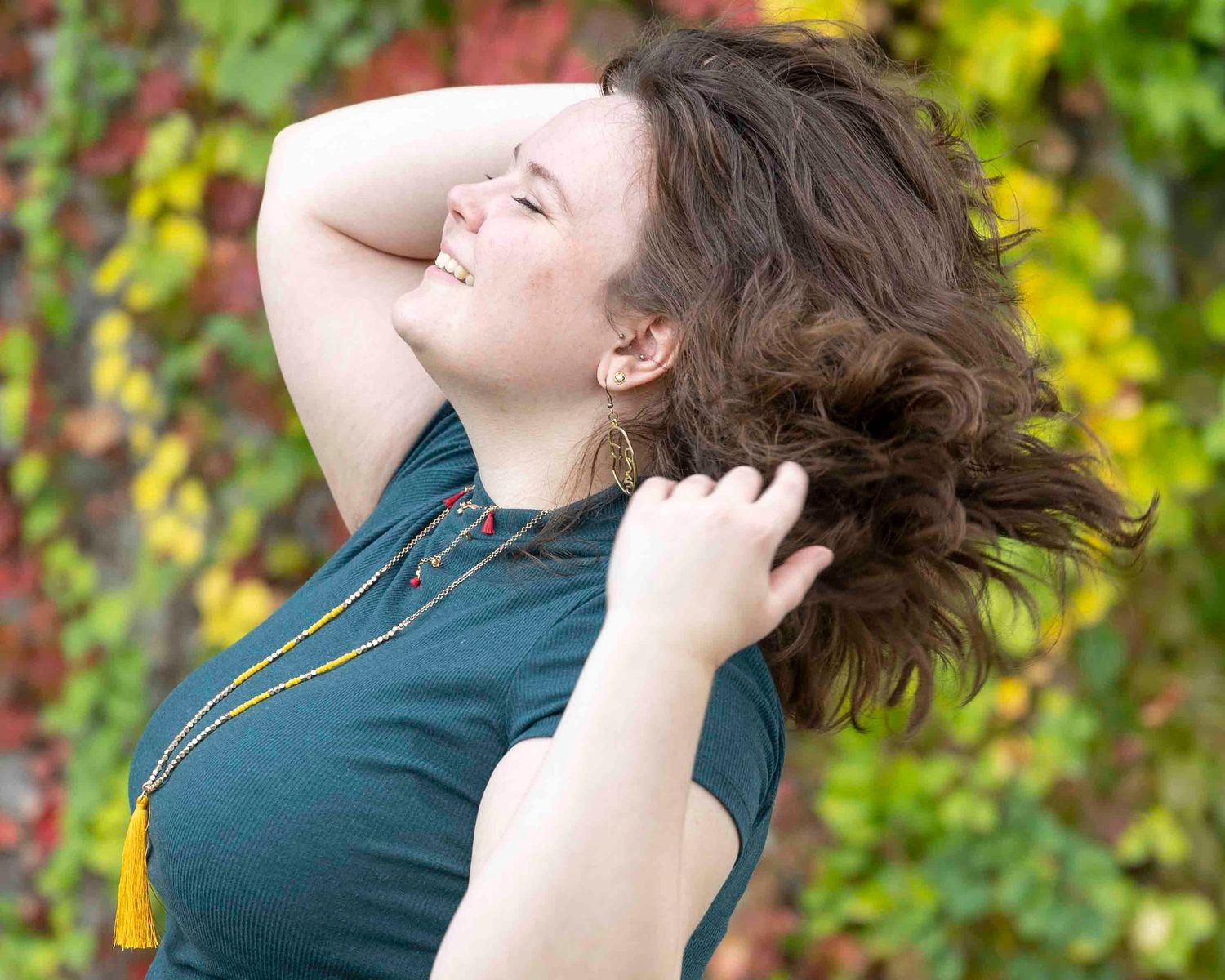 Candid outdoor shot showing movement and joy against colorful autumn leaves.