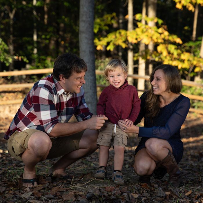 A joyful family interaction in a wooded setting during golden hour.